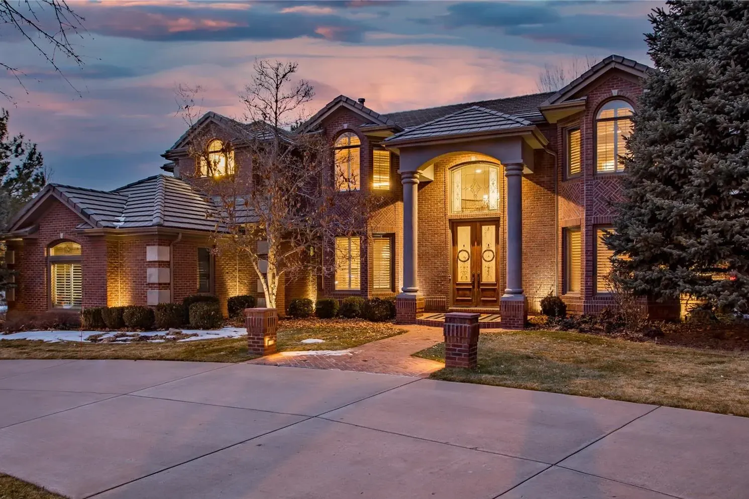 A brick residence lit at dusk at 4791 E Perry Parkway in The Preserve at Greenwood Village, one of our past sales